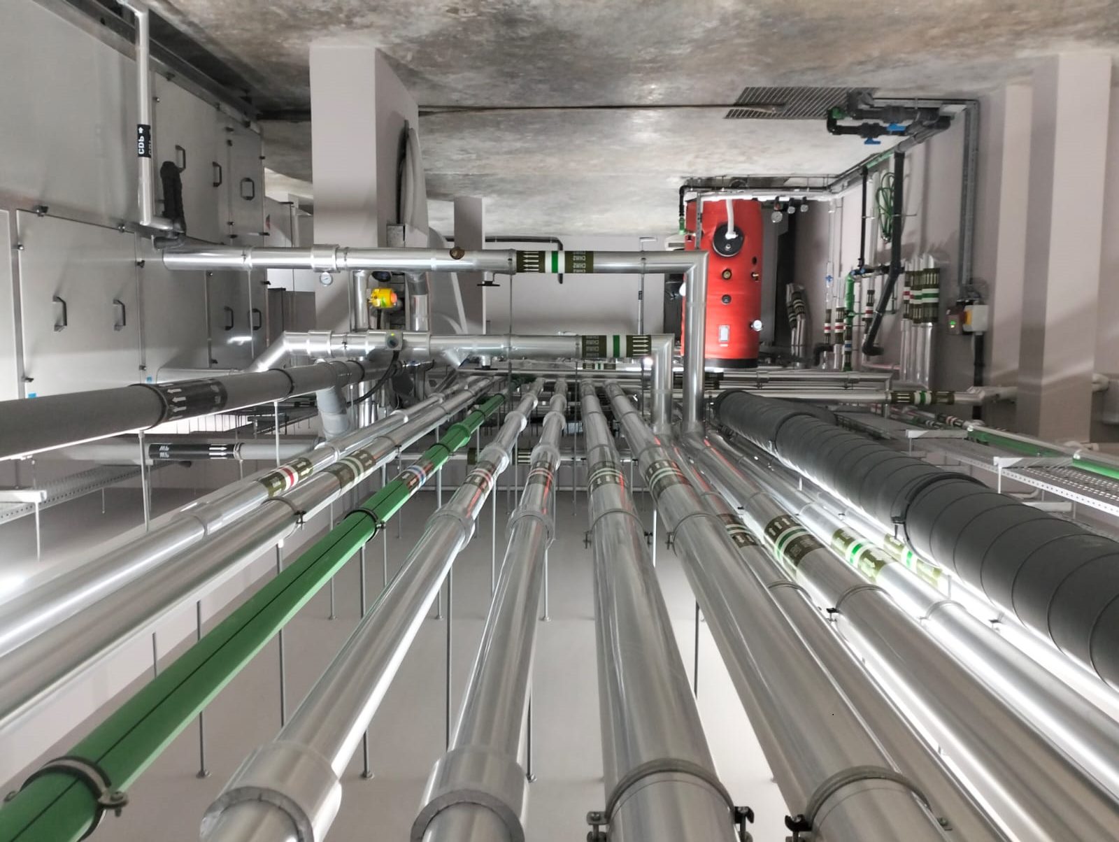 Insulated pipework runs and pump sets in a building services plant room