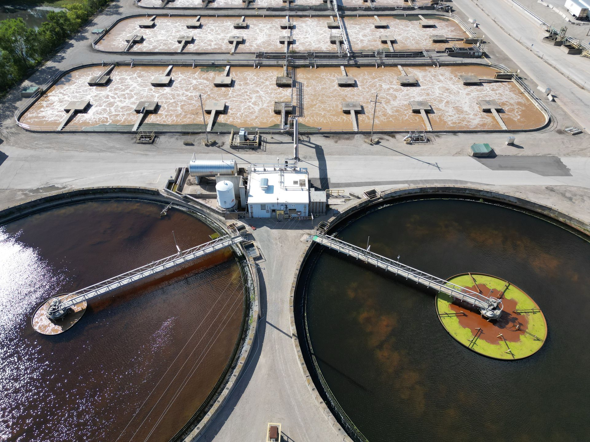 Aerial view of a water treatment plant with circular clarifier tanks and aeration basins
